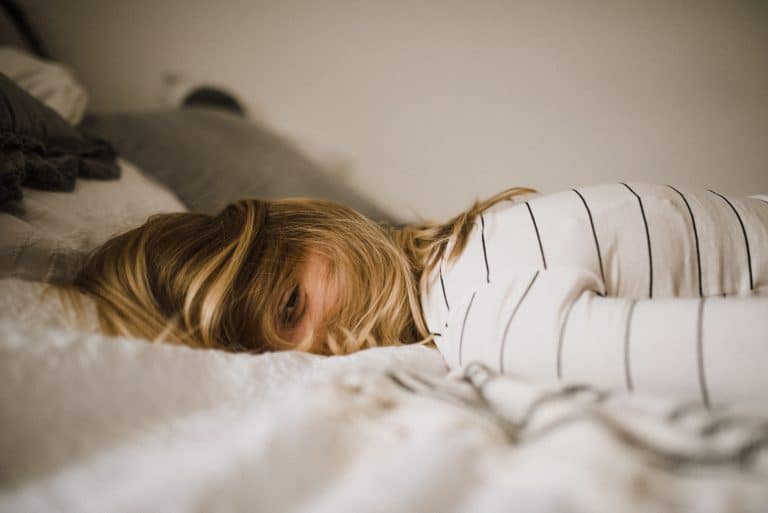 Woman lying down on a bed.